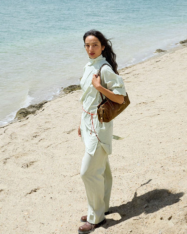 Yore Baguette Bag in Sandal color carried by a woman on a beach