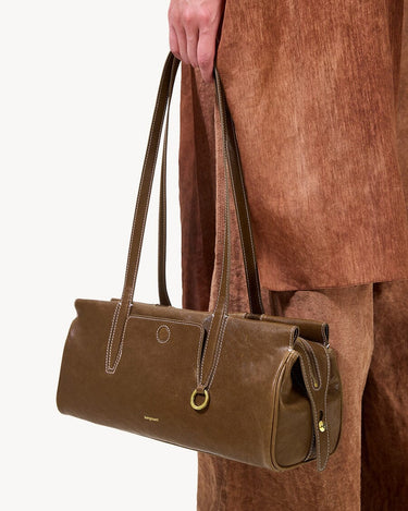 Yore Baguette Bag in Sandal color, made of vegetable-tanned leather with white stitching and gold hardware.