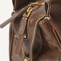 Brown Yore Baguette Bag: vegetable-tanned leather, gold hardware, white stitching. Embossed Songmont logo.
