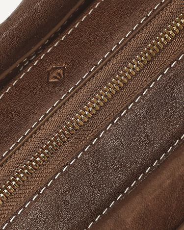 Yore Baguette Bag in Sandal color, featuring vegetable-tanned leather, white stitching, and a gold zipper.
