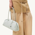Pale blue Yore Toast bag made of full-grain leather with SS 304 hardware, held by a person.