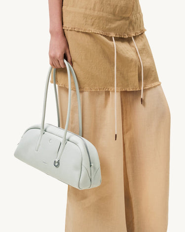 Pale blue Yore Toast bag made of full-grain leather with SS 304 hardware, held by a person.