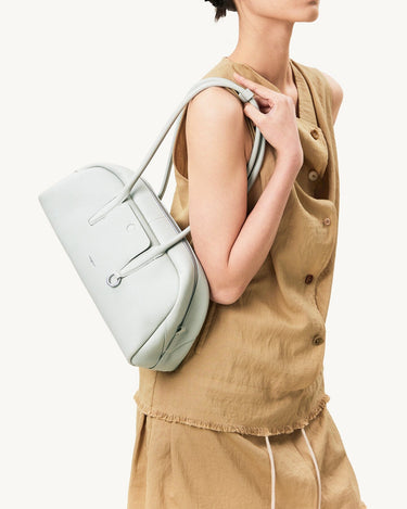 Pale blue full-grain leather Yore Toast Bag with vacuum electroplated hardware worn by a model.
