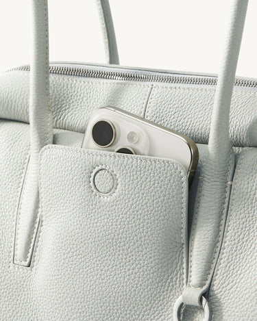 Light blue full-grain leather Yore Toast Bag with phone in front pocket and silver hardware.