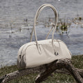 Songmont Yore Toast Bag in Cloud color, made of full-grain tumbled leather, with a smooth, rounded silhouette and elegant handles.