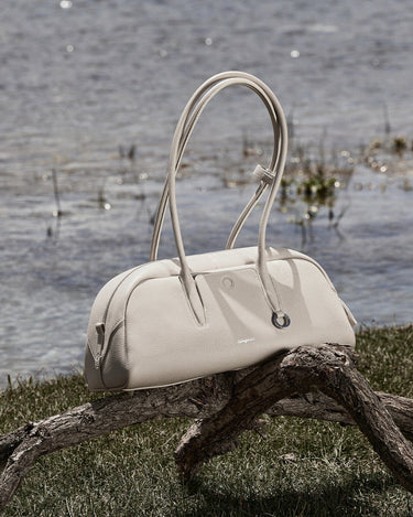 Songmont Yore Toast Bag in Cloud color, made of full-grain tumbled leather, with a smooth, rounded silhouette and elegant handles.