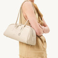 Yore Toast Bag in Cloud, a cream pebble-grain leather handbag with rounded shape and silver hardware.