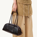 Yore Toast Bag in Ebony: a baguette-shaped shoulder bag made from smooth nappa leather with white stitching.