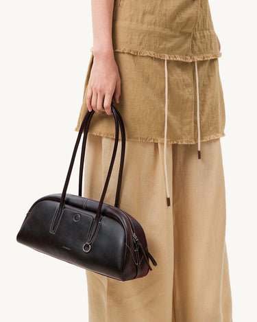 Yore Toast Bag in Ebony: a baguette-shaped shoulder bag made from smooth nappa leather with white stitching.