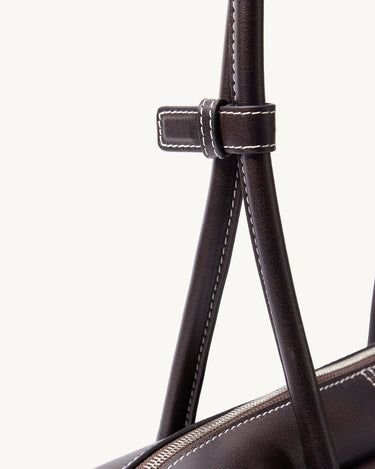 Dark brown Yore Toast Bag by Songmont, featuring leather handle with contrast stitching and silver zipper detail.